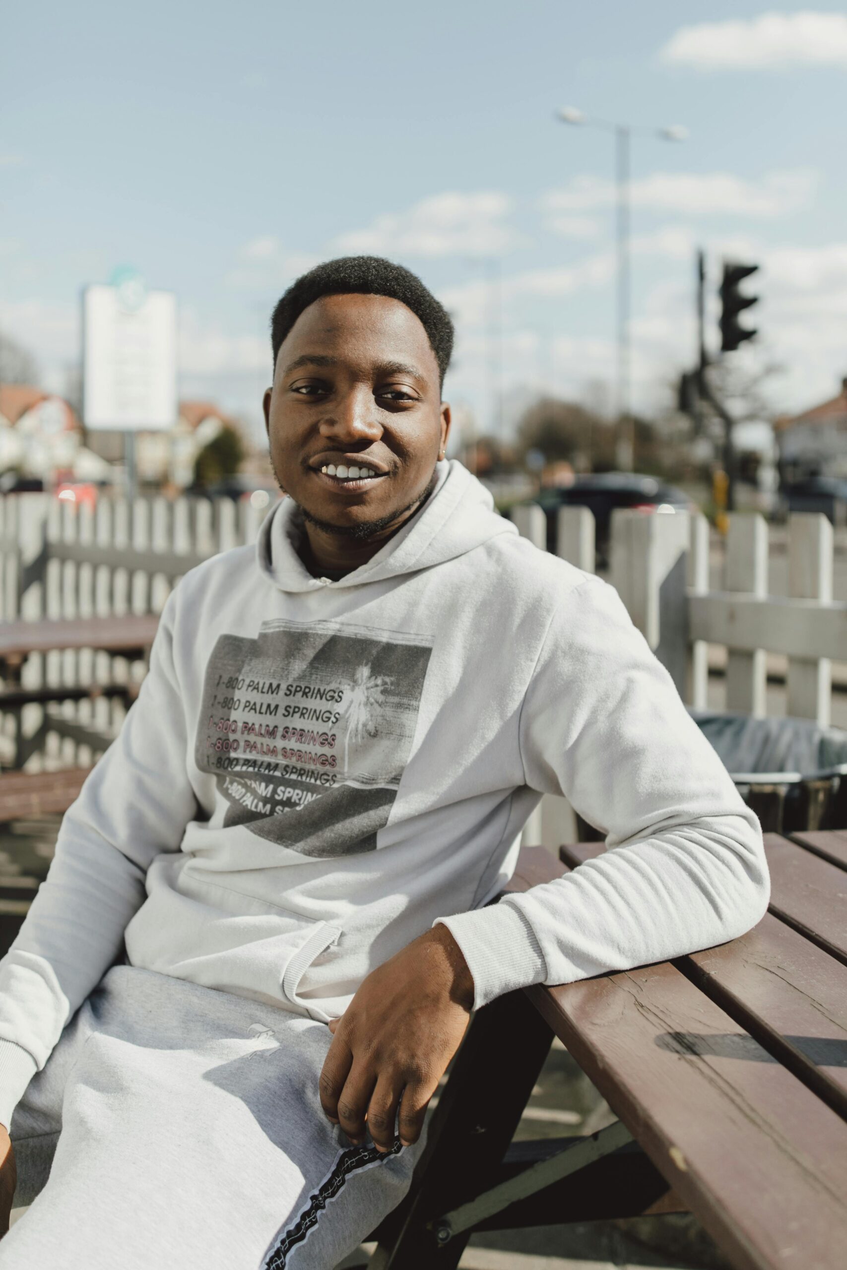 pexels-photo-2058659-2058659 Smiling adult man in a hoodie outdoors, enjoying a sunny day.